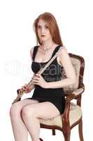 Woman sitting with flute on an old armchair