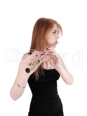 Woman standing, playing the flute in close up