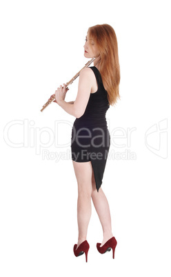 Woman standing from back, holding her flute