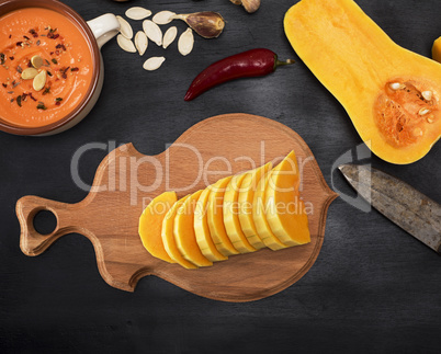 pumpkin is sliced into pieces on a kitchen cutting board