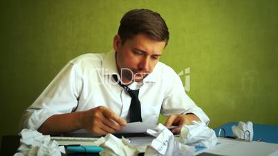 Overworked businessman trying working with documents in an office. Overload concept.