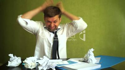 Angry stressed businessman smashing keyboard. Stress at a workplace.