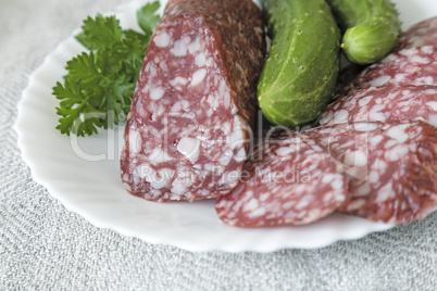 Slices of sausage and cucumber on the plate.