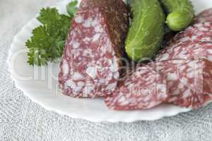 Slices of sausage and cucumber on the plate.