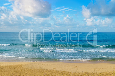 Deserted sandy beach of the Indian Ocean. In the blue sky cumulu