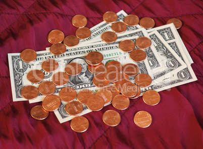 Dollar notes and coin, United States over red velvet background