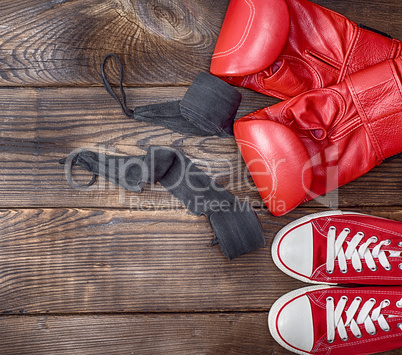 pair of red textile sneakers and red leather boxing gloves