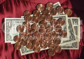 Dollar notes and coin, United States over red velvet background