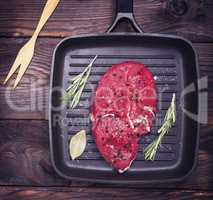 raw beef steak on a black quart pan