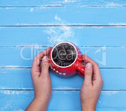 red cup with hot black coffee in female hands