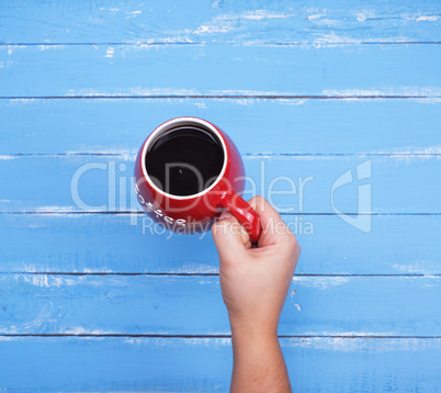 red ceramic cup with black coffee