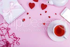 pink background with a cup of tea in a white cup