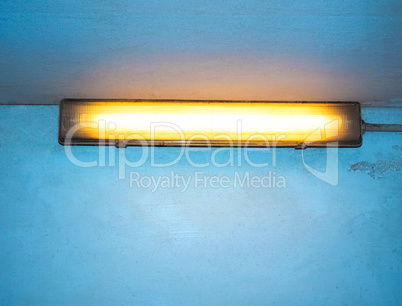 Yellow neon light over blue wall with copy space