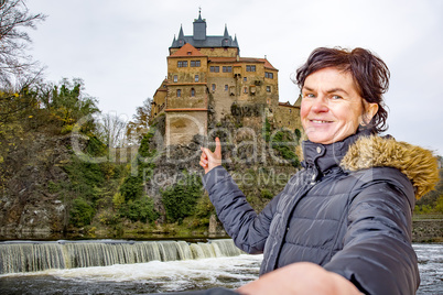 Woman points to the castle Kriebstein