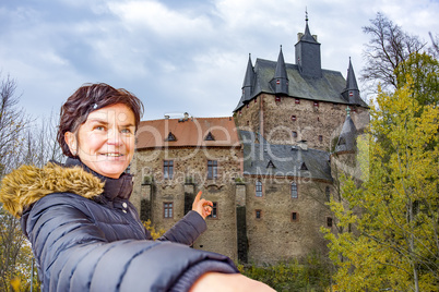 Woman points to the castle Kriebstein