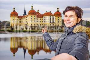 Woman points to the castle of Moritzburg