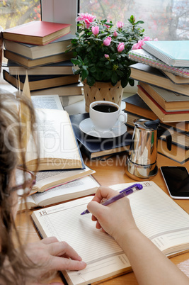 A woman is taking notes in a notebook