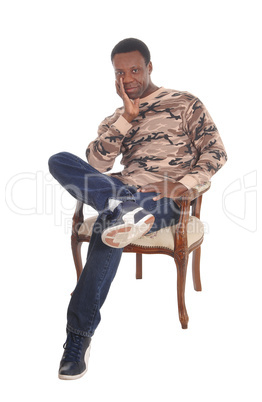Tall African American man sitting in armchair