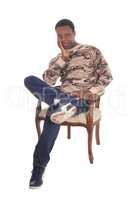 Tall African American man sitting in armchair