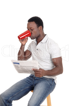 African man drinking coffee, reading the paper