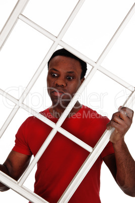 Surprised African man holding up a window frame