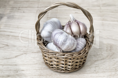 Garlic in a wicker basket on the table.