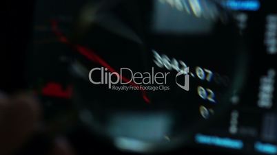 Stock market trading data on a screen through magnifier. Selective focus. Financial information background.