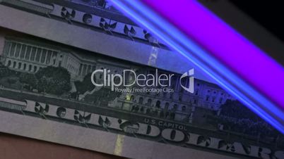 Close up shot of scanning dollar banknotes under UV light.