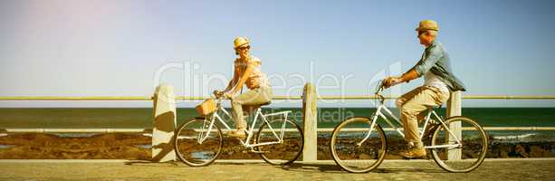 Happy couple riding bicycles on pier