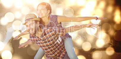 Composite image of man piggybacking woman with arms outstretched