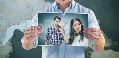 Composite image of man holding picture of couple disputing