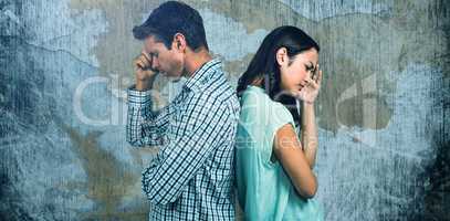 Composite image of depressed couple standing back to back