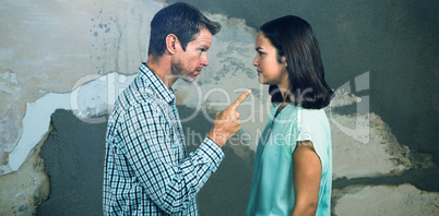 Composite image of side view of man pointing woman while arguing