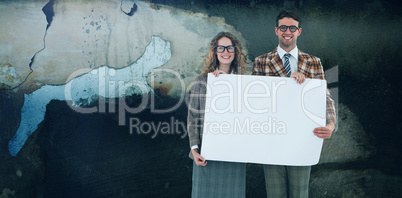 Composite image of geeky hipster couple holding poster