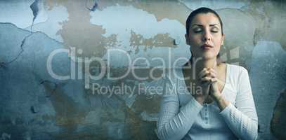 Composite image of beautiful woman praying with joining hands and eyes closed