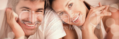 Enamoured couple having fun lying on bed