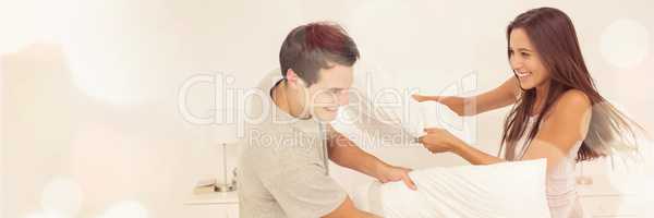 Couple having fun with a pillow fight