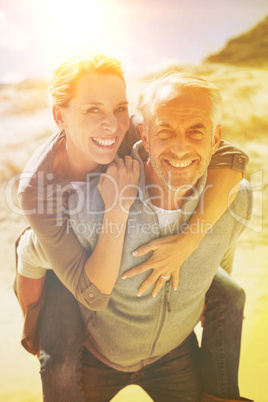 Laughing couple smiling at camera on the beach