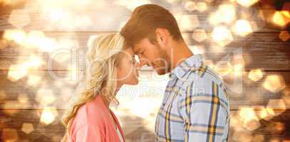 Composite image of attractive couple standing touching heads