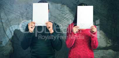 Composite image of couple hiding faces with blank papers
