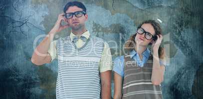 Composite image of geeky hipster couple thinking with hand on temple