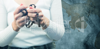 Composite image of midsection of woman holding rosary beads