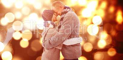 Composite image of happy mature couple in winter clothes hugging