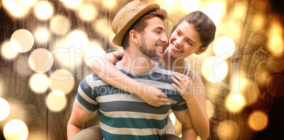 Composite image of man piggybacking woman while smiling