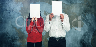 Composite image of couple hiding face with papers