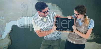 Composite image of geeky hipster couple holding little blackboard
