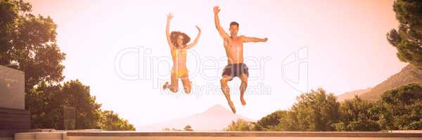 Cheerful couple jumping into swimming pool