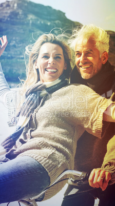 Carefree couple going on a bike ride on the beach