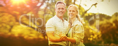 Happy couple holding hands against trees