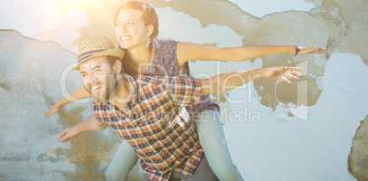 Composite image of man piggybacking woman with arms outstretched